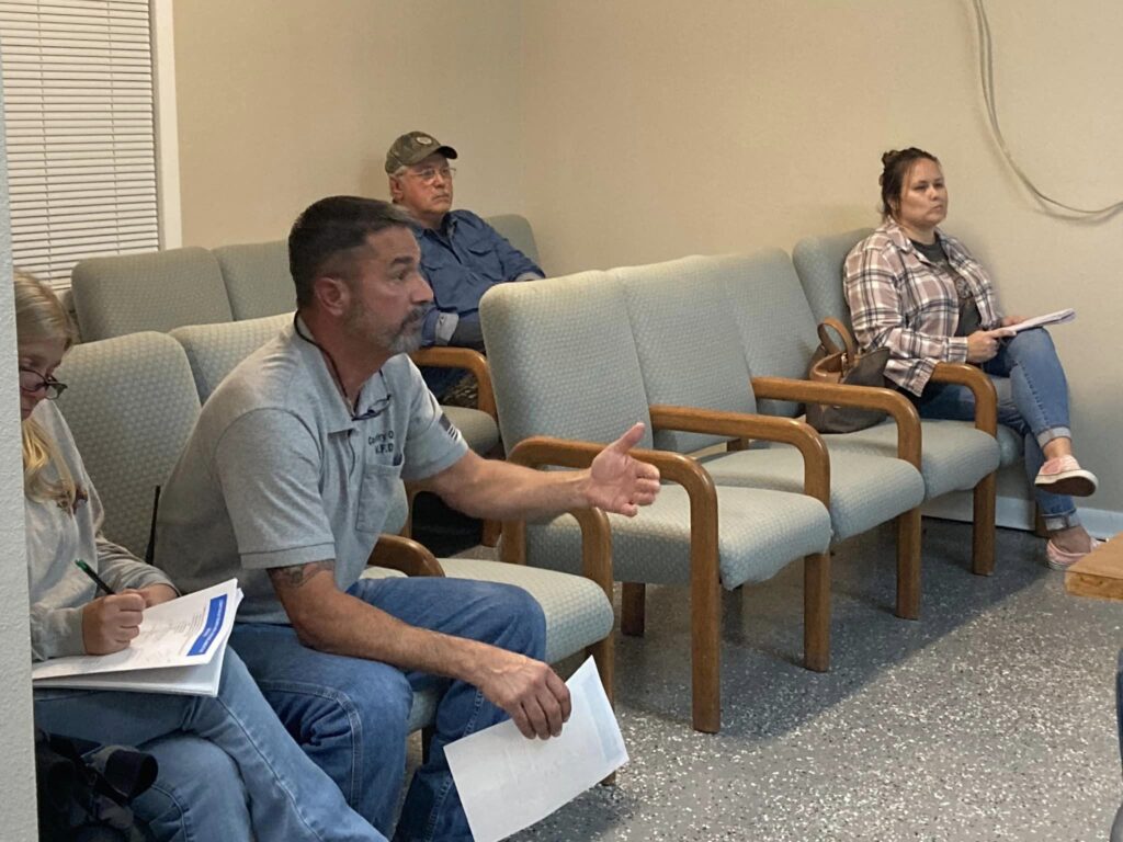 A group of people sitting in chairs talking.