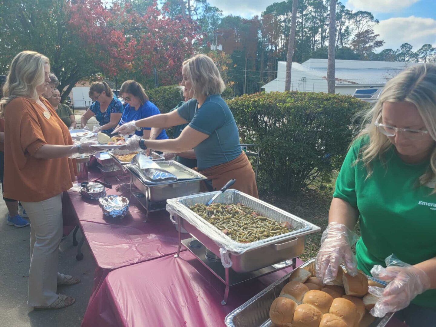 People serving food at outdoor event. People serving food at outdoor event.
